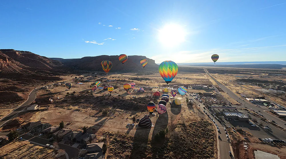 A view from above shows hot air balloons on a sunny day in Kanab, Utah