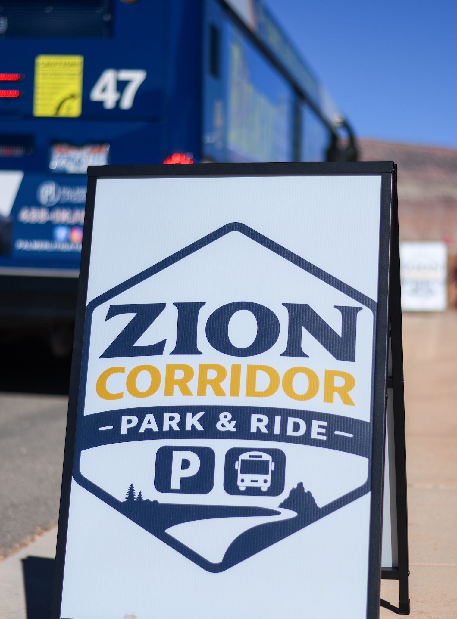Alt text: Zion Corridor Park & Ride sign and blue SunTran bus in background